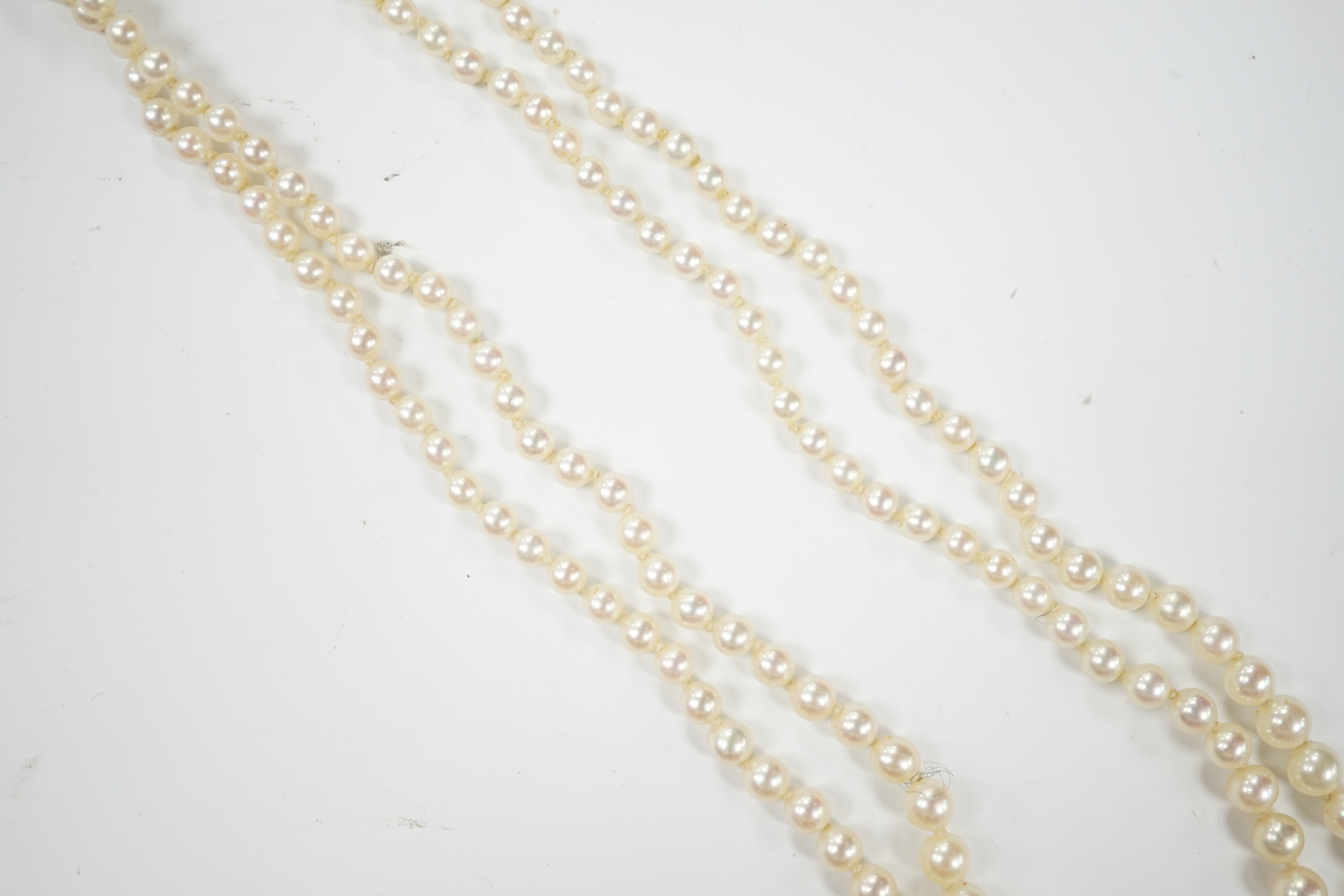 A 1940's French double strand graduated cultured pearl necklace, with diamond set white metal clasp (18ct poincon mark), 46cm.